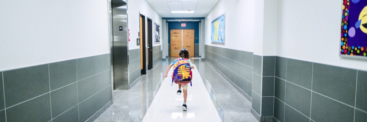 Child running down school hallway